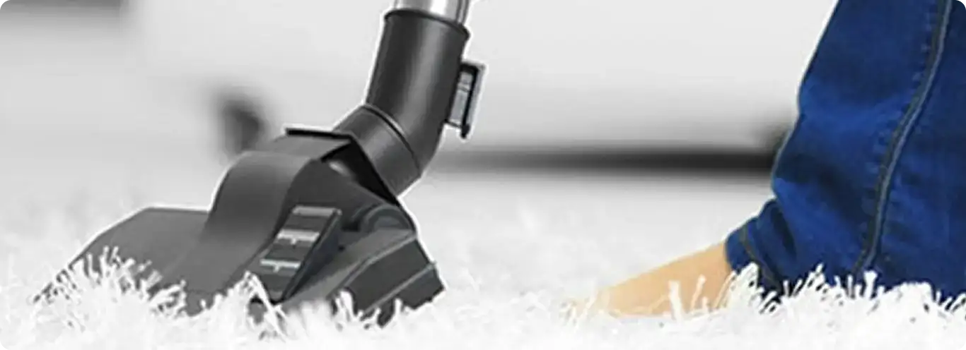 Close-up of a professional vacuuming a white carpet in Bluffton.