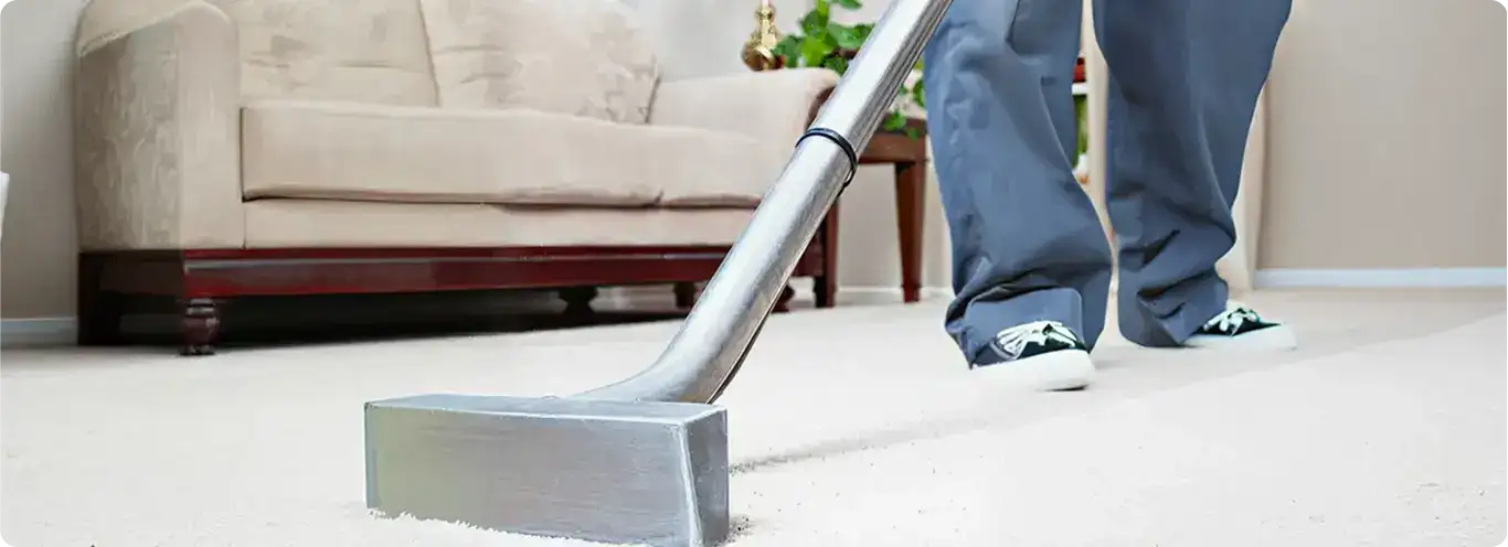 Carpet cleaning technician using a hot-water extraction wand on a light-colored carpet in a living room, Savannah, GA.